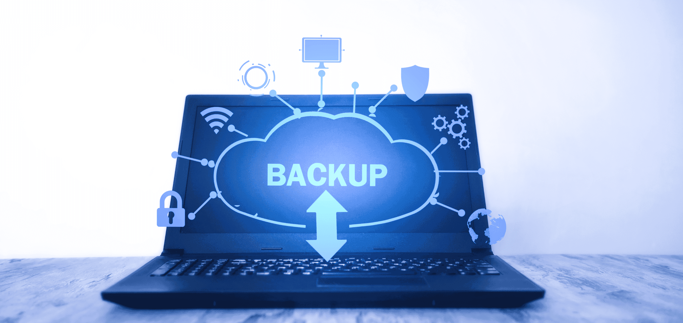Laptop mit Backup-Schriftzug innerhalb einer Wolke, die mit verschiedenen icons verbunden ist, um Vernetztheit und Sicherheit zu symbolisieren